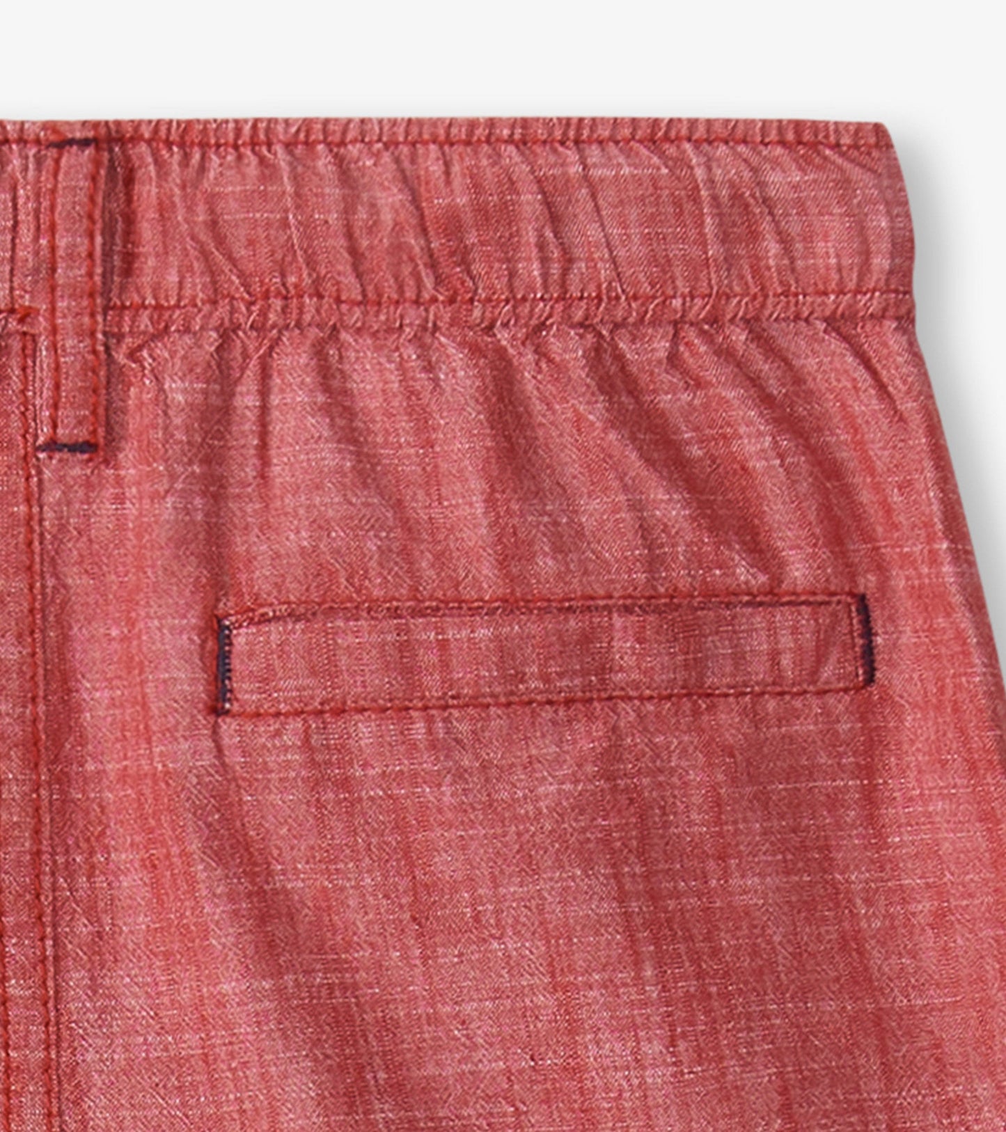 Red chambray woven shorts with an elastic waistband and a back pocket, suitable for casual summer wear.