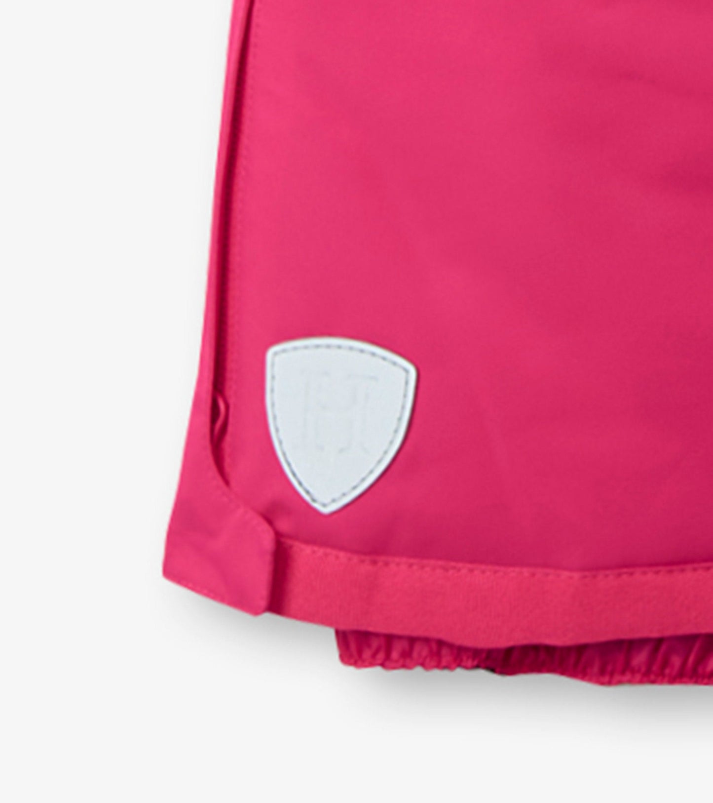 Bright pink snow pants with elastic cuffs and a white logo patch, designed for kids' winter activities.