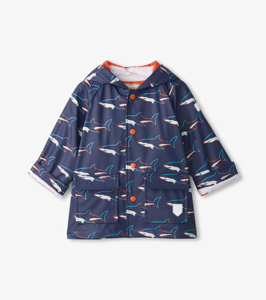 Navy raincoat featuring a shark pattern, button-up front, hood, and two front pockets. Suitable for baby and toddler boys.
