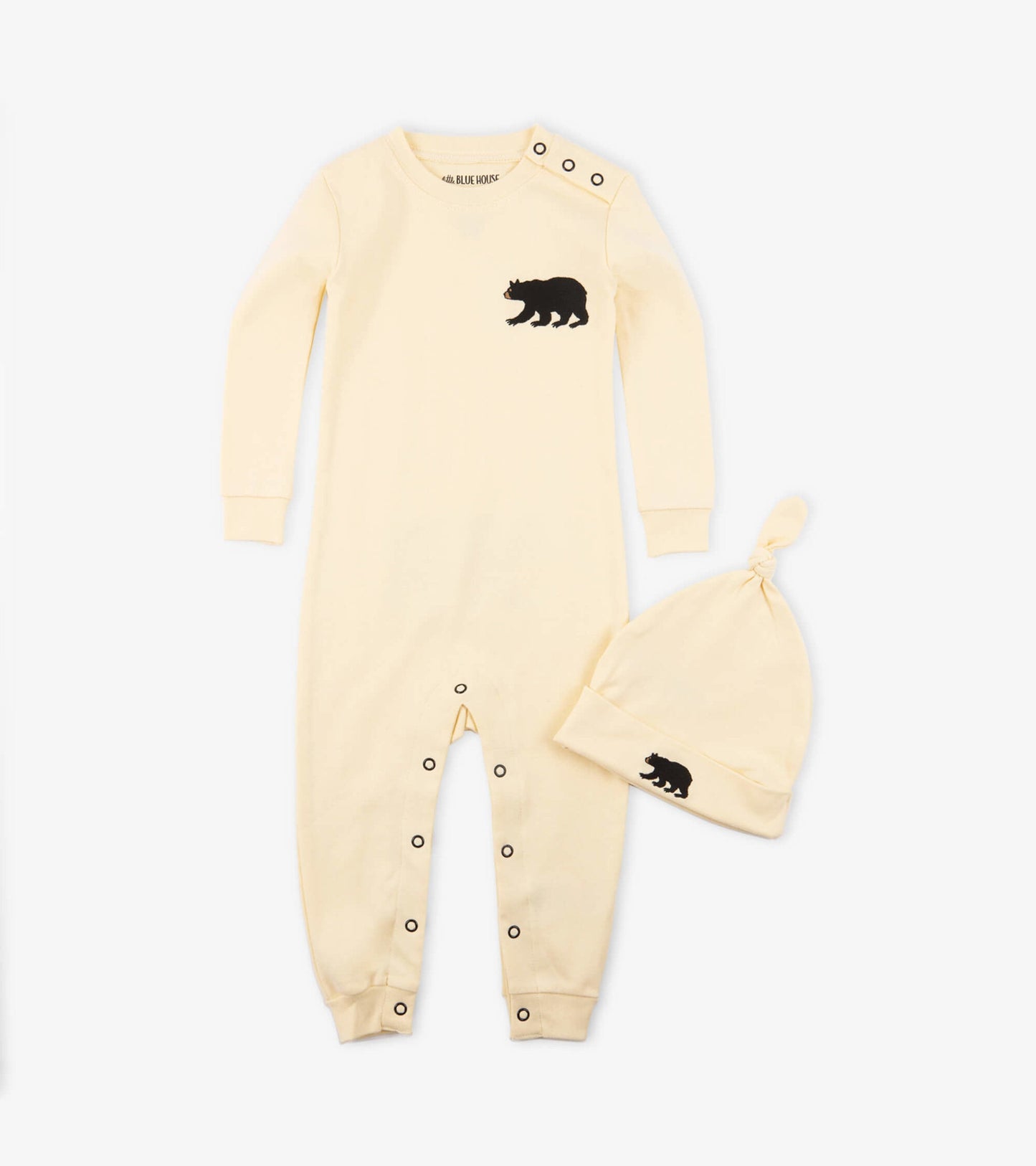 Cream-colored baby sleeper with black bear design and matching hat, featuring snap closures and long sleeves.