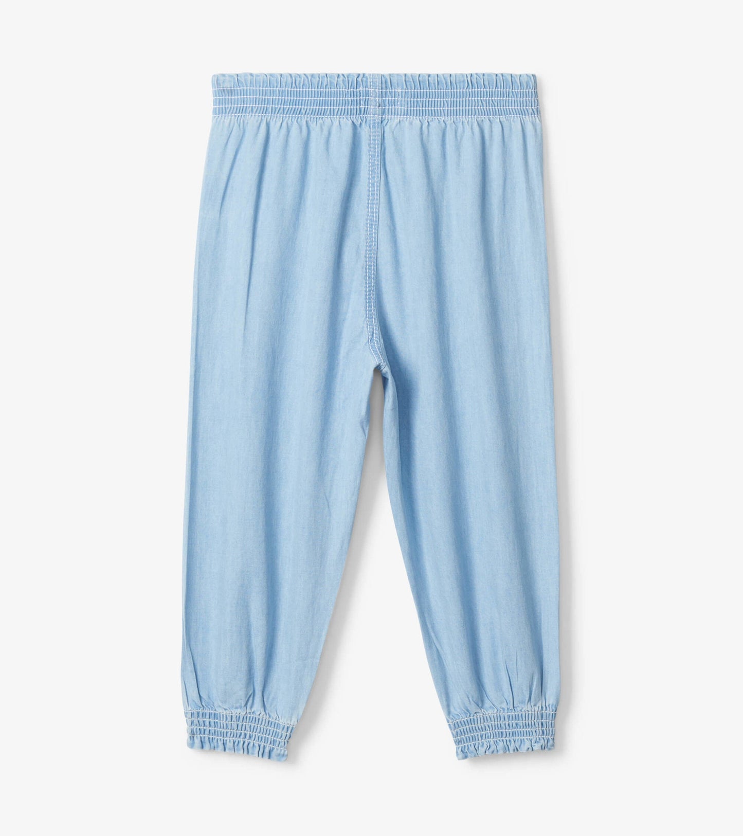 Light blue denim baggy pants for baby and toddler girls with an elastic waistband and gathered cuffs.