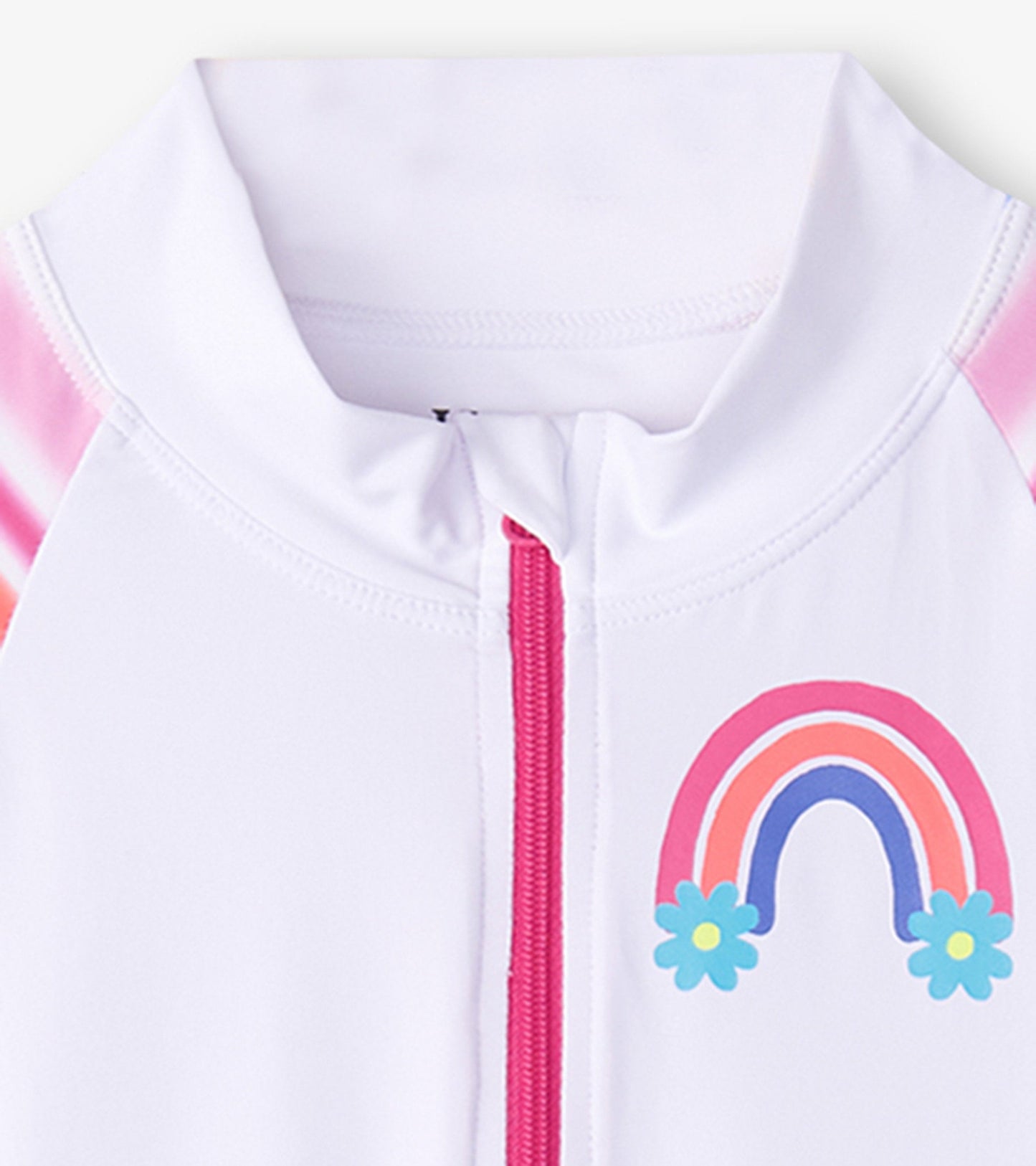 White rashguard with pink stripes, front zipper, and rainbow graphic with flowers. Suitable for kids' swimwear.