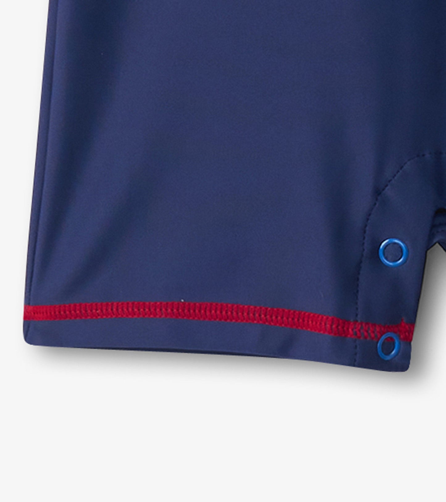 Navy blue one-piece rashguard with red stitching and snap closures, designed for baby boys.