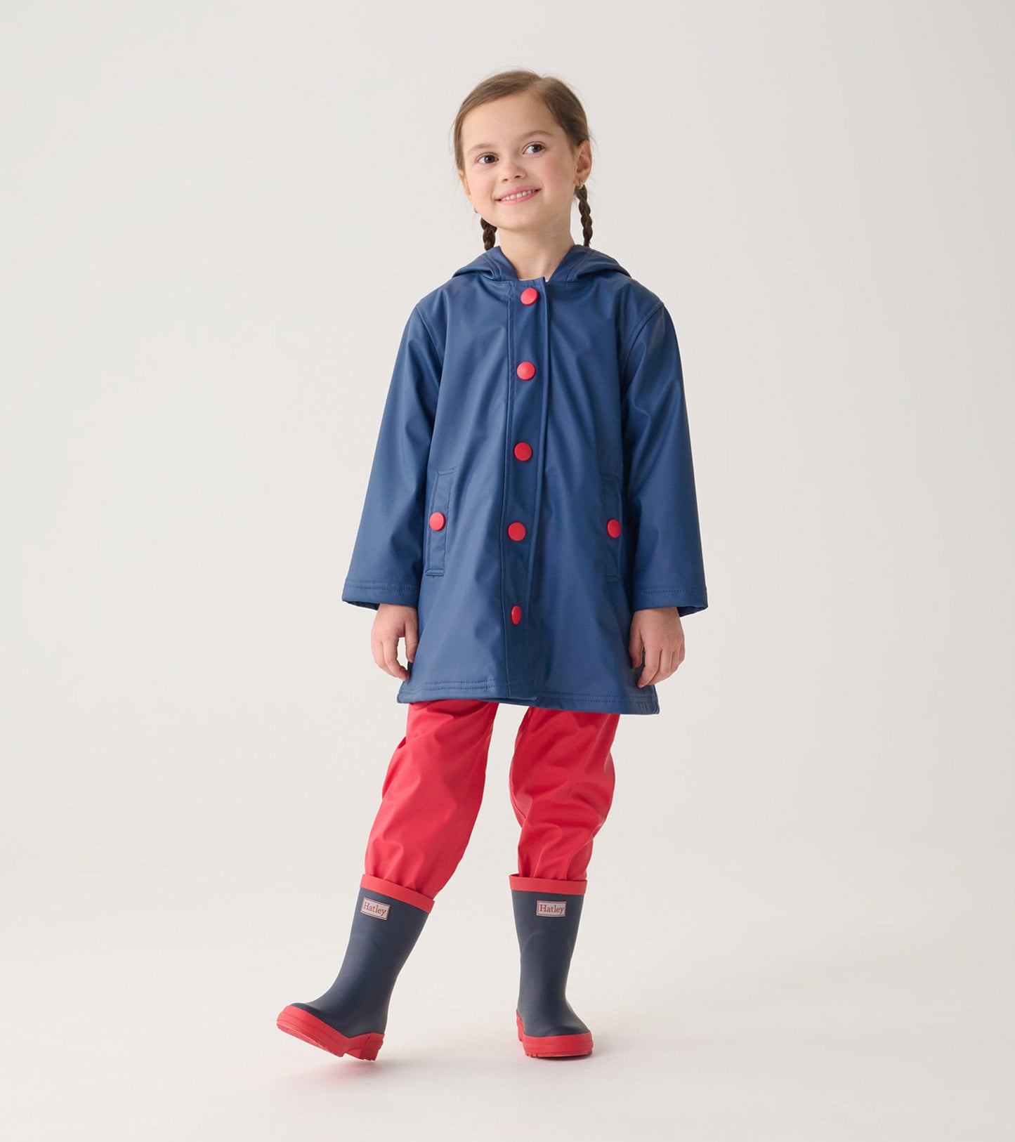 Navy and red matte wellies on a child, paired with a navy raincoat and red pants, suitable for wet weather.