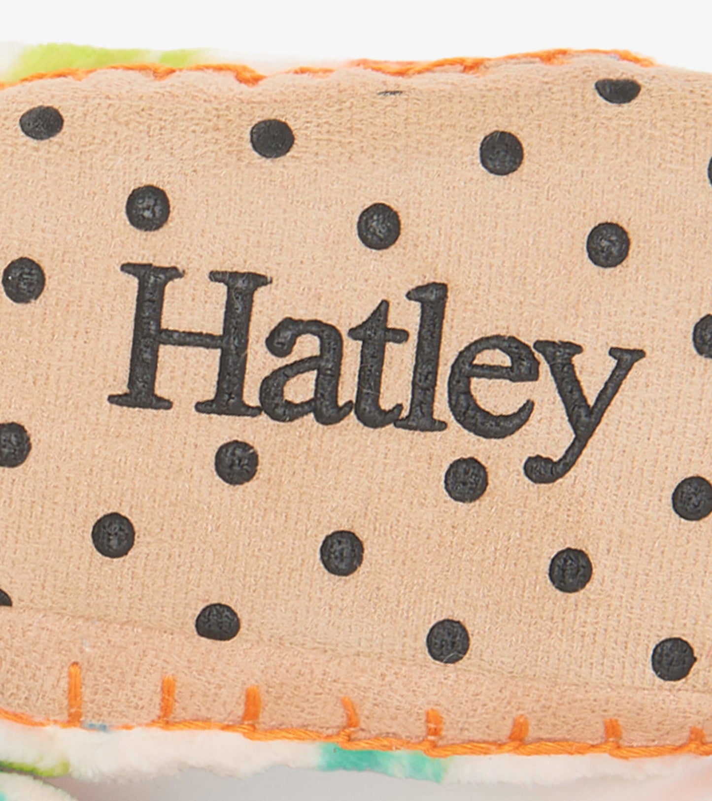 Fleece slippers featuring a colorful dinosaur pattern, soft lining, and a textured sole for grip.