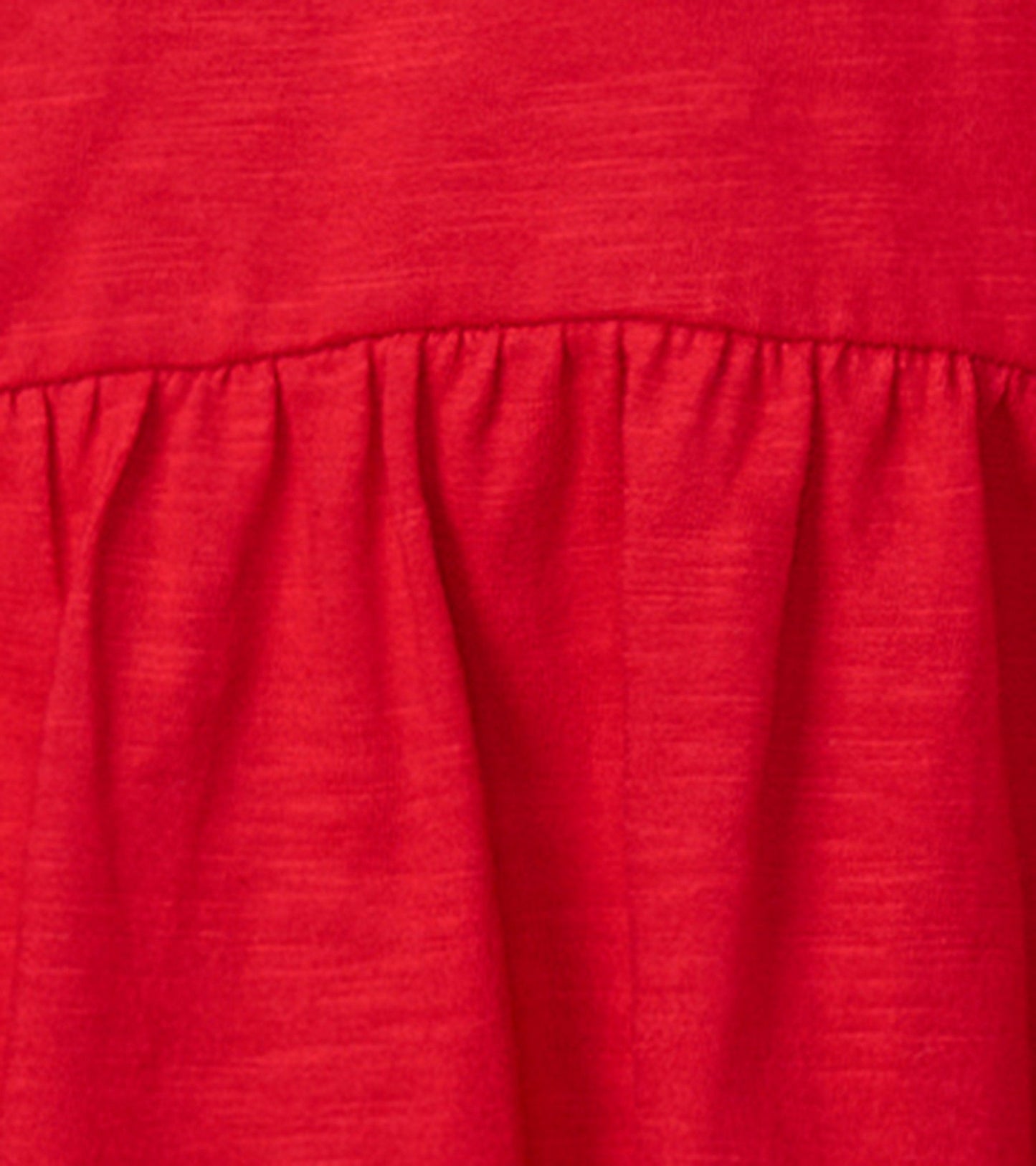 Red holiday party dress featuring a gathered waist and soft fabric, ideal for festive occasions.