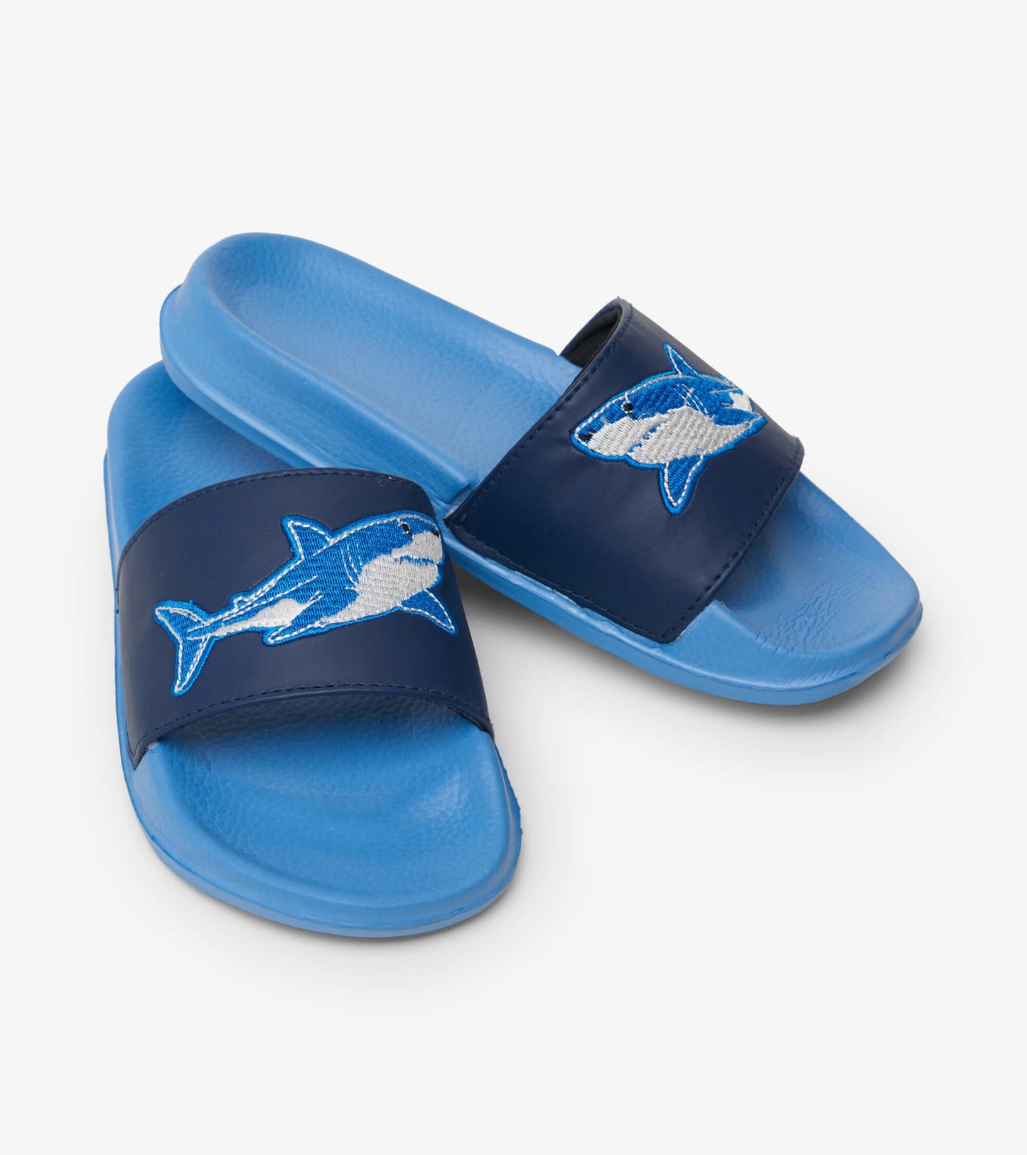 Blue slide sandals featuring a shark design on a navy strap, ideal for casual wear.