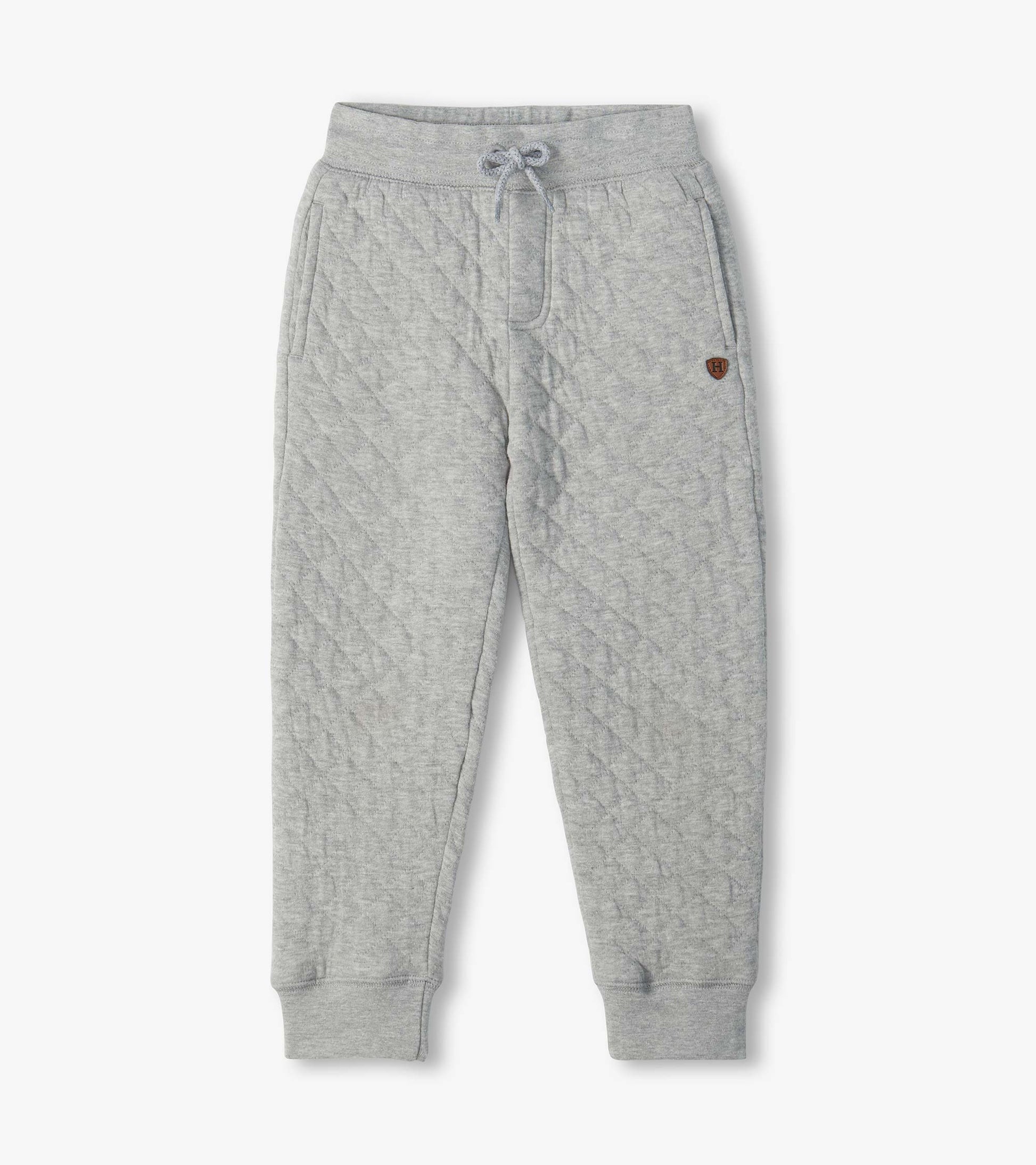 Grey quilted jogger pants with drawstring waist, side pockets, cuffed ankles, and small H patch
