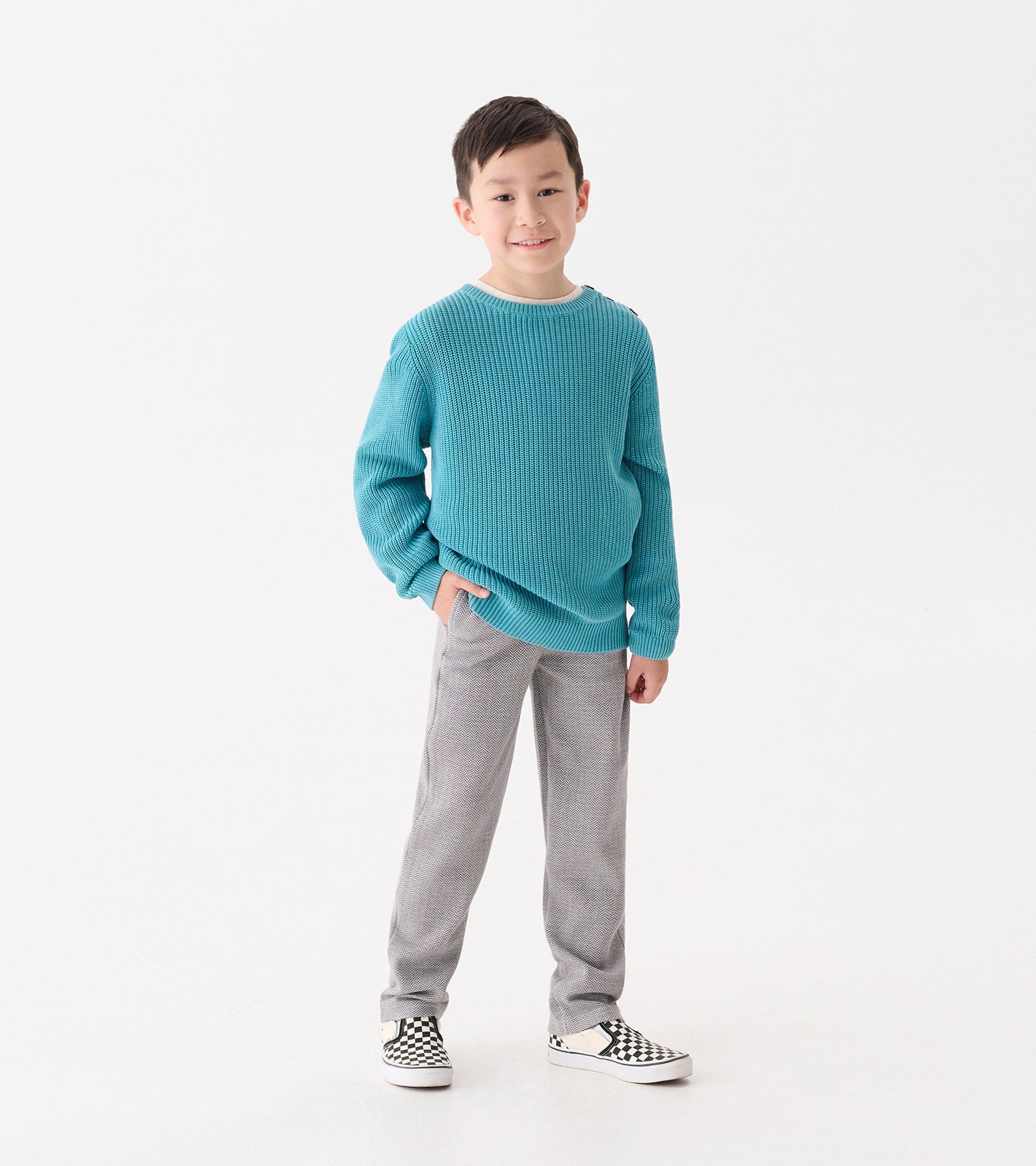 Dark grey herringbone straight leg pants for boys, styled with a casual sweater and checkered shoes.