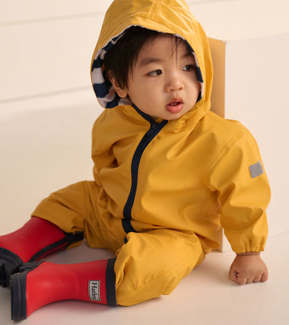 Close-up of a yellow hooded baby rain suit with striped hood lining and red rain boots