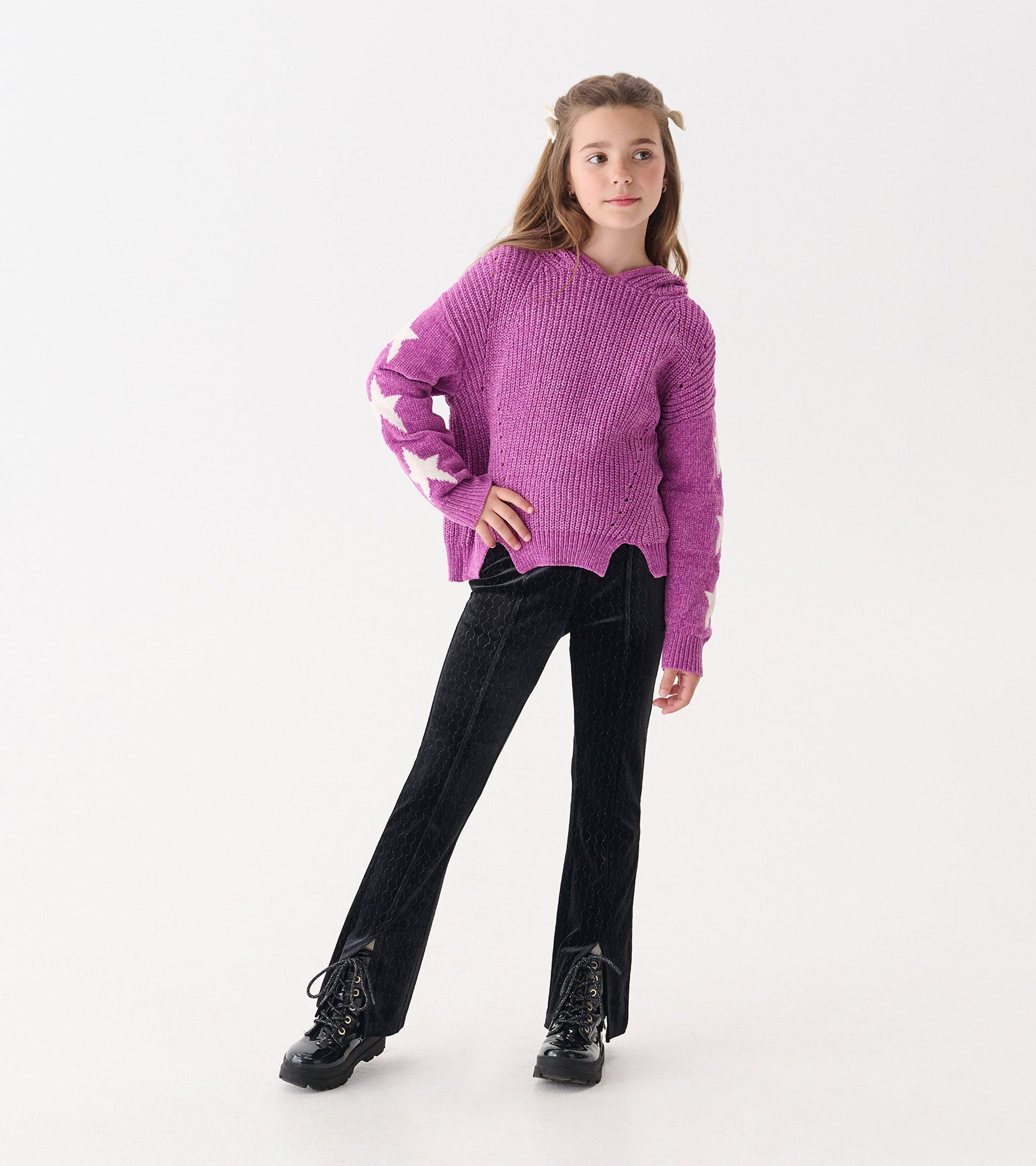 Black velour flared pants with a sparkle wave pattern, styled with a purple sweater and black lace-up boots.