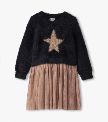 Black fuzzy top with a gold star design, paired with a pleated, shimmery pink skirt.