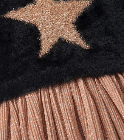 Black top with a gold star design and a pleated, shimmery rose gold skirt.