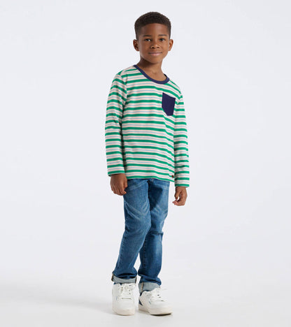 Green and white striped long sleeve bamboo t-shirt with a navy pocket, worn with blue jeans and white sneakers.