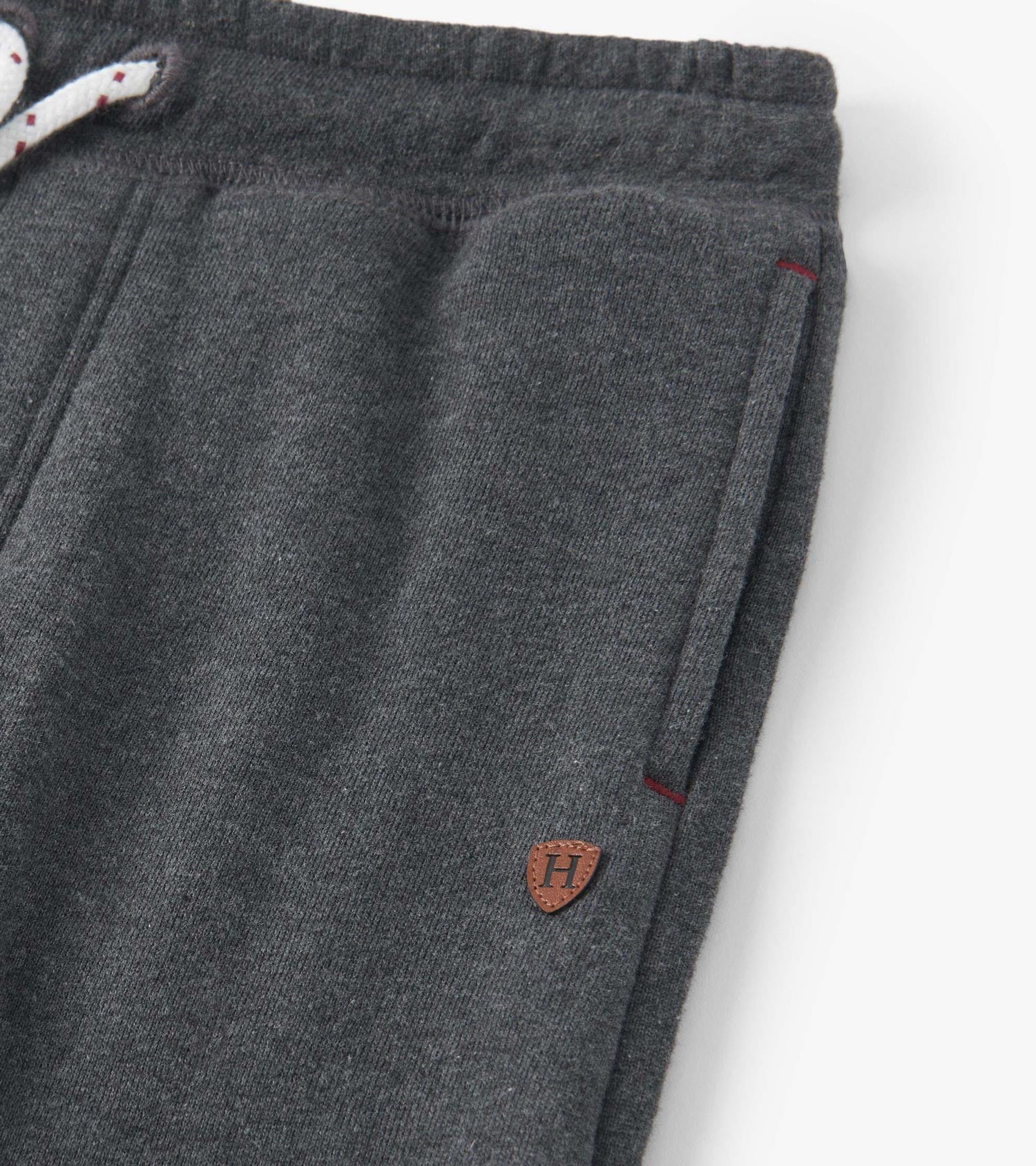 Charcoal melange joggers with a drawstring waist, side pockets, and a small logo patch. Soft fabric for comfort.