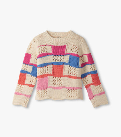Cream sweater featuring a mix of colorful patchwork patterns in pink, blue, and red with a round neckline and long sleeves.