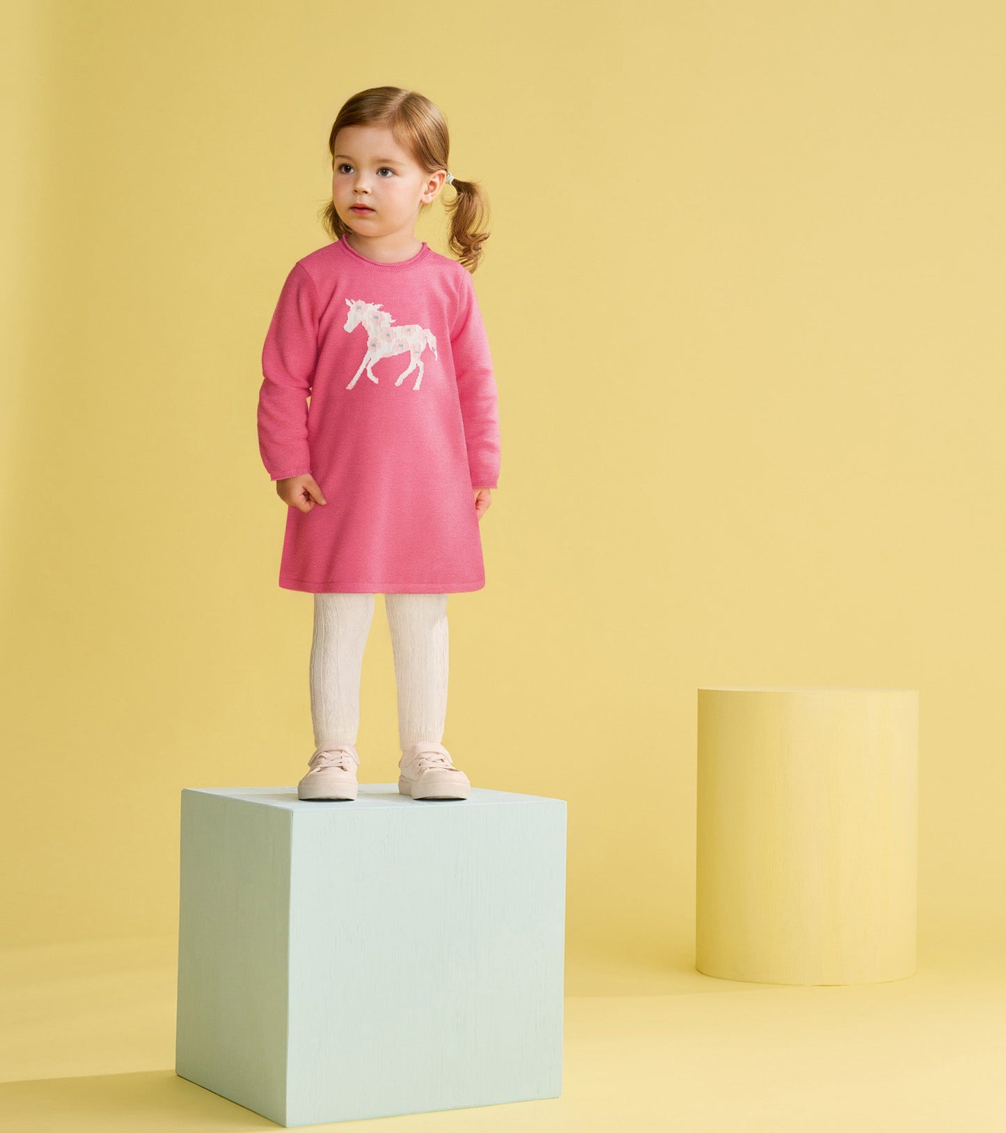 Pink sweater dress featuring a white horse design, paired with white textured leggings and light pink shoes.