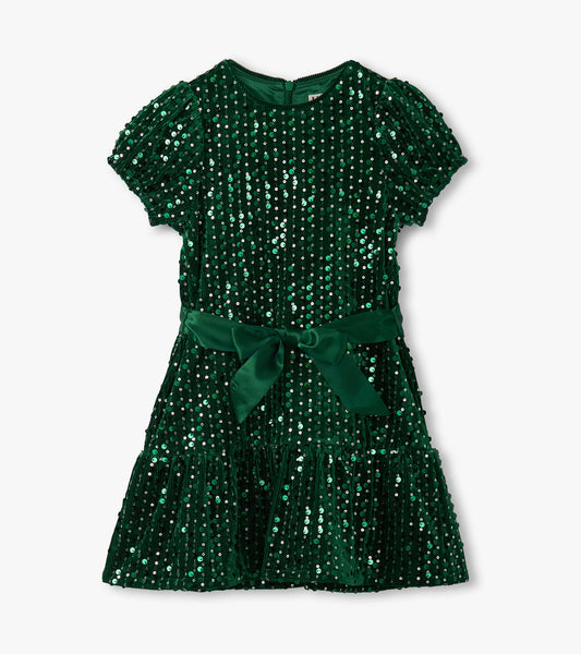 Green velvet dress adorned with sequins, featuring short puff sleeves and a ruffled hem, tied with a matching belt.