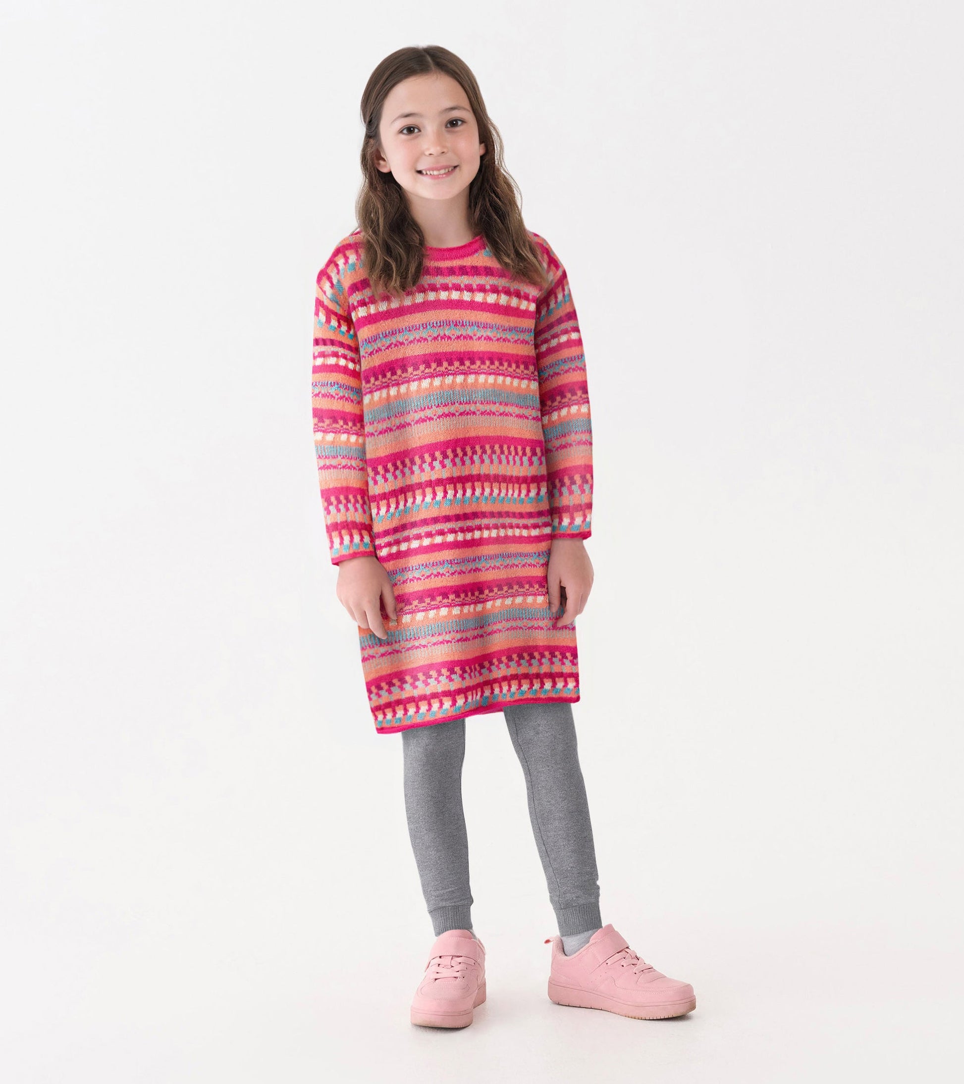 Pink and multicolored striped sweater dress with long sleeves, paired with gray leggings and pink shoes.