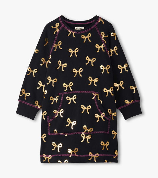 Black sweater dress featuring gold bow patterns and a front pocket, with purple stitching details.