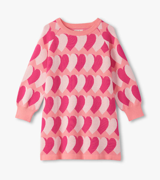 Pink sweater dress featuring a heart pattern in varying shades of pink, with long sleeves and a round neckline.