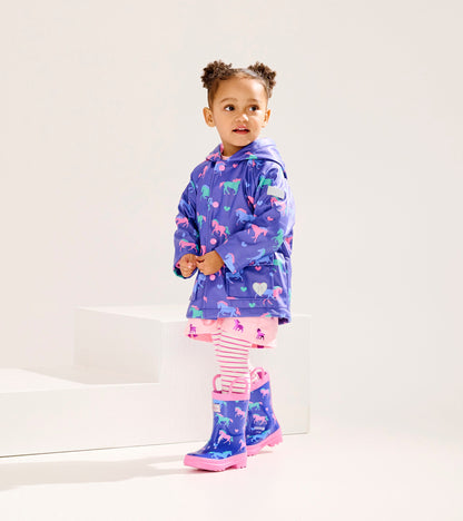 Purple button-up raincoat with horse and heart patterns, paired with pink striped leggings and matching rain boots.