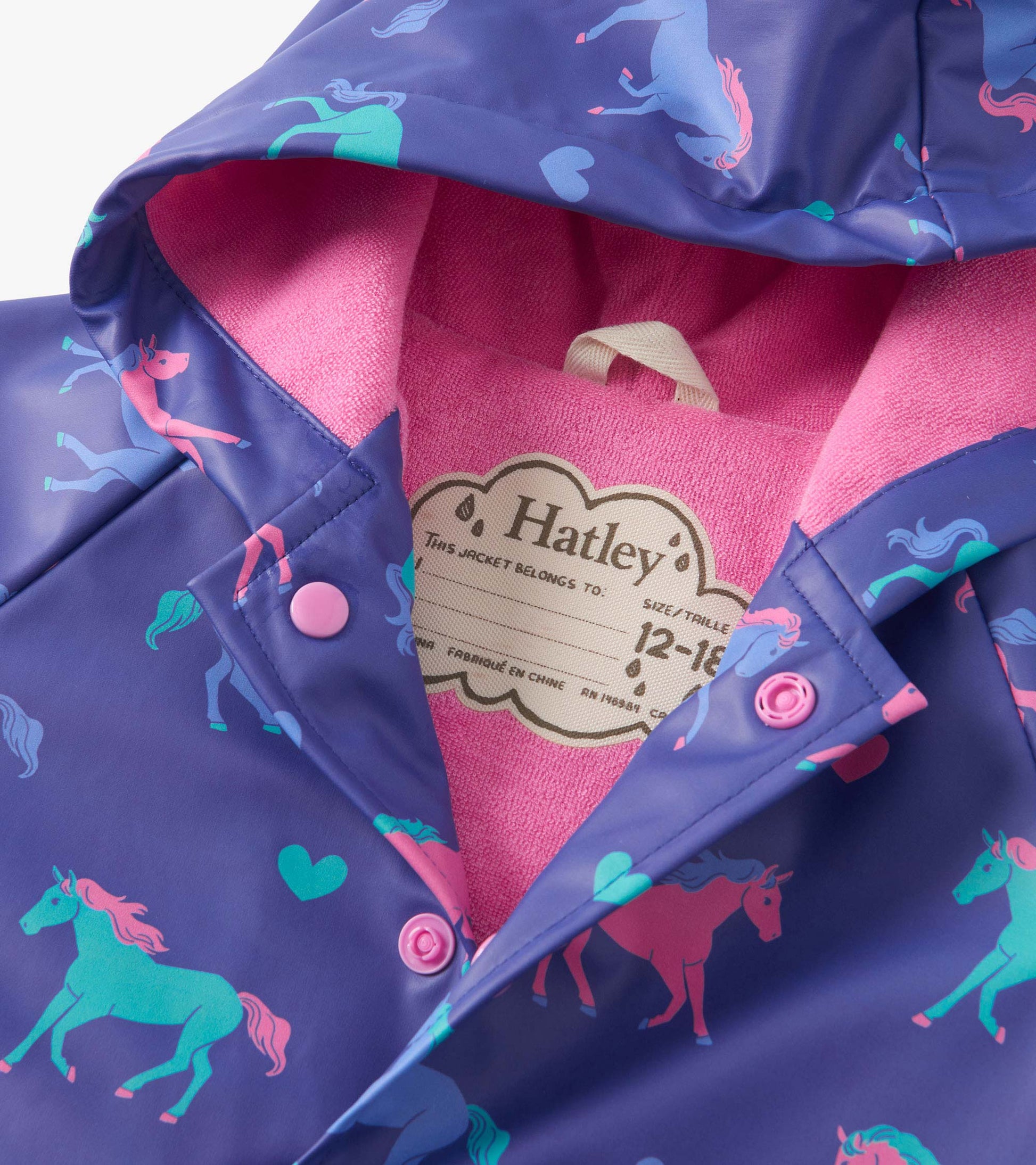 Purple raincoat featuring colorful hearts and horses, with a pink fleece lining and snap closures.