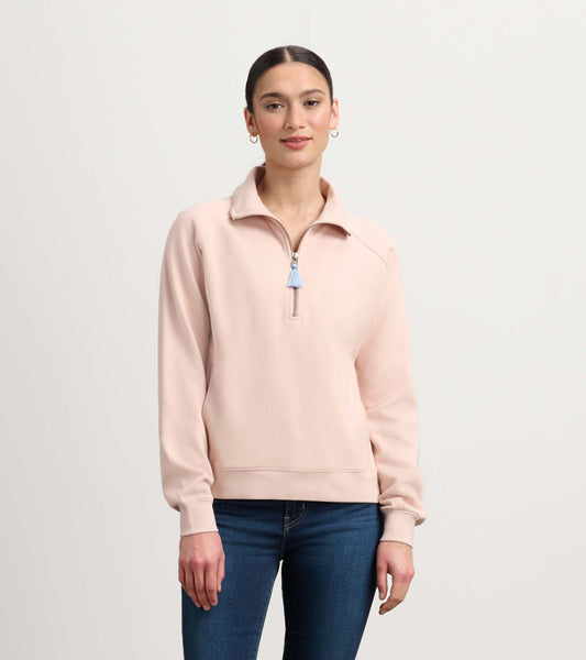 Pink mock neck pullover with a zip front and long sleeves, styled with blue zipper pull, paired with jeans.