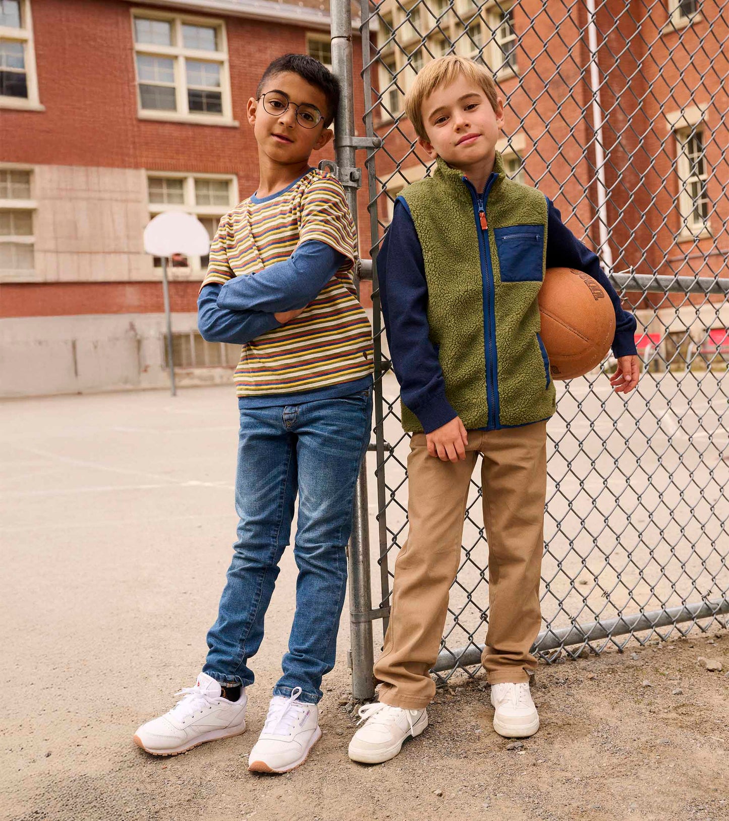 Loden green faux sherpa vest with navy accents, worn by a boy holding a basketball, paired with khaki pants.