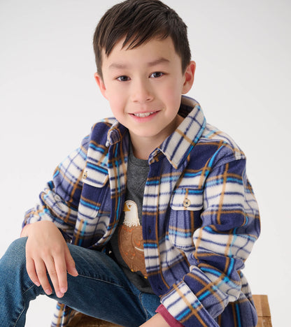 Plaid fleece button-up shirt in blue, white, and brown, featuring two chest pockets, worn by a boy sitting casually.