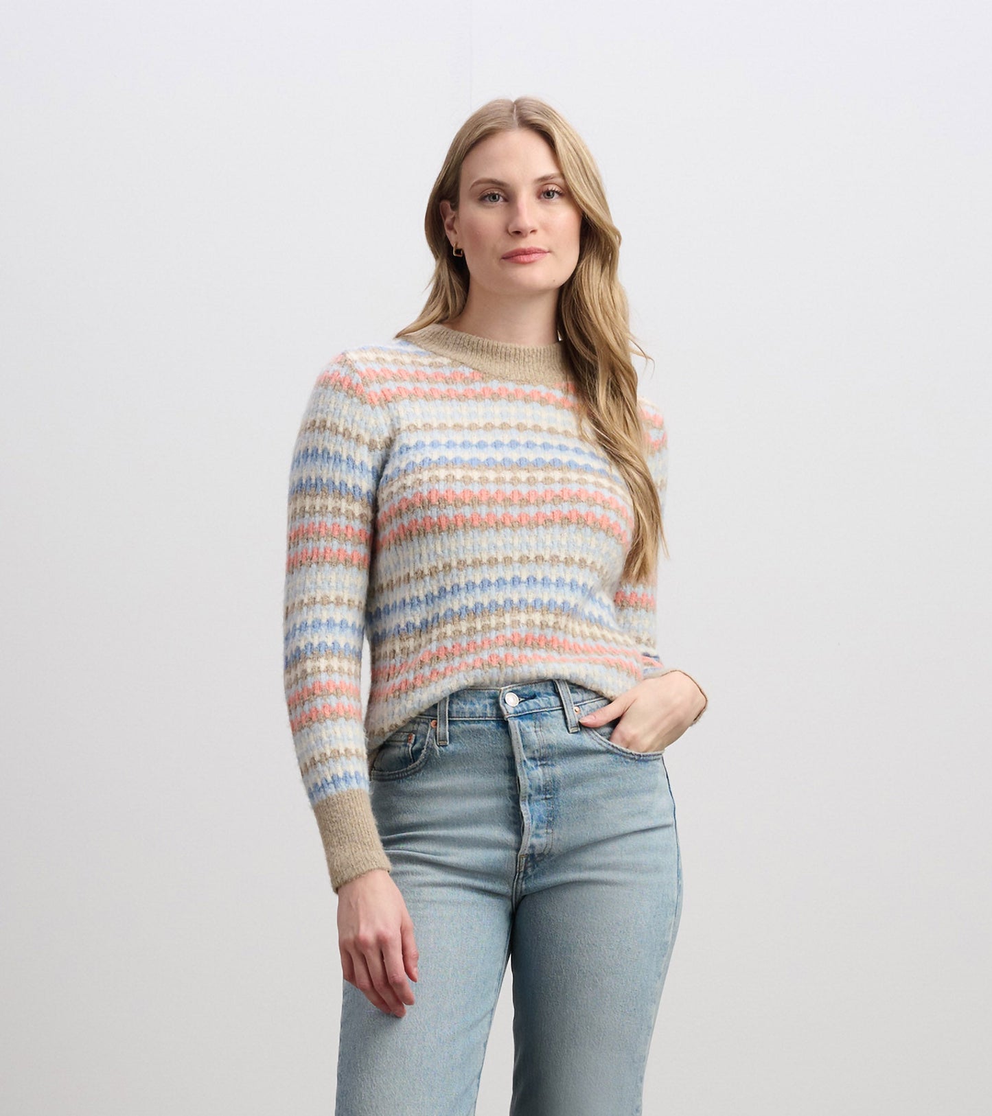 Knit jumper featuring bubble stripes in pastel colors, with a round neckline and long sleeves, paired with light blue jeans.