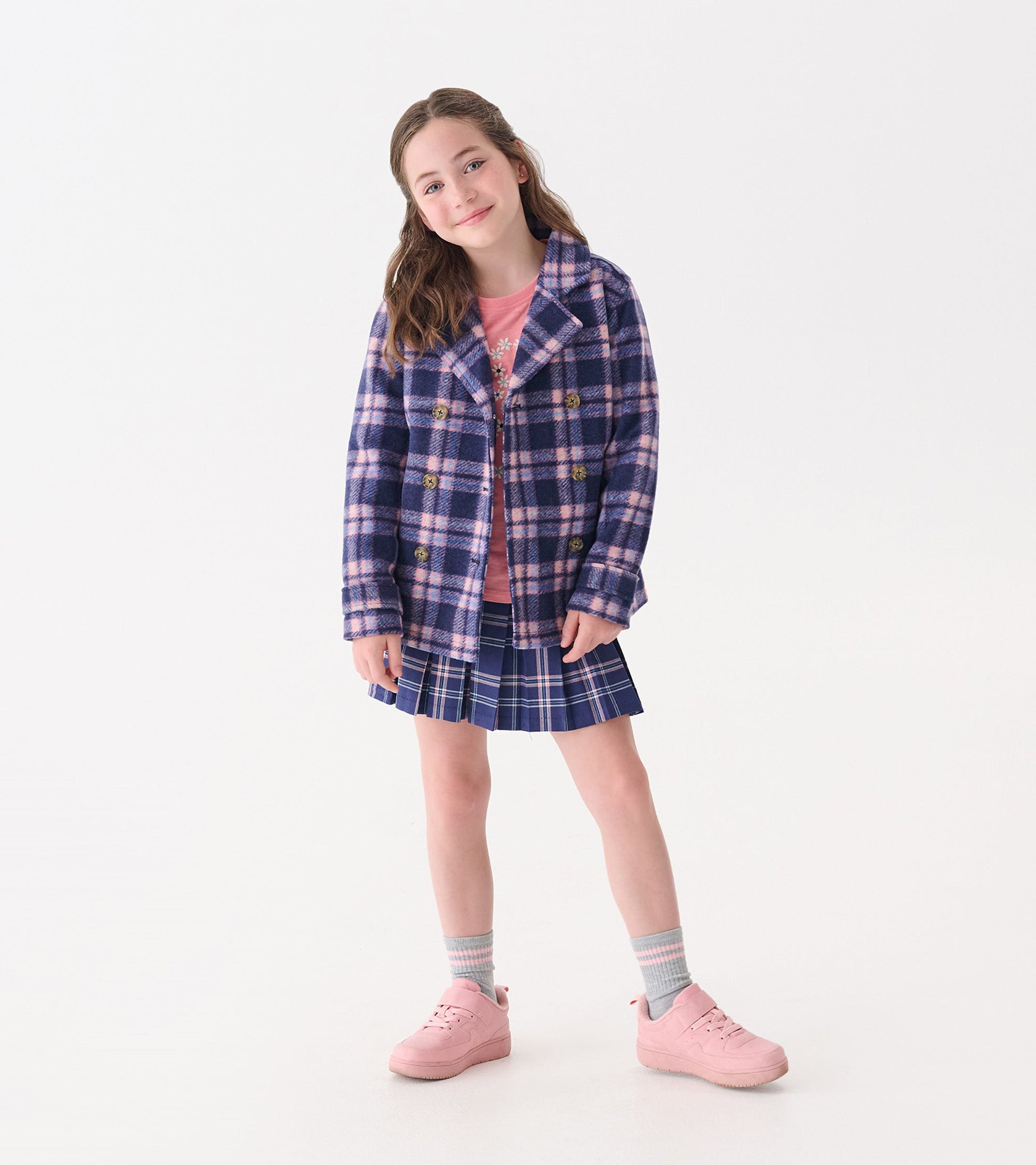 Navy plaid pleated skirt with blue and green accents, styled with a pink top and matching sneakers.