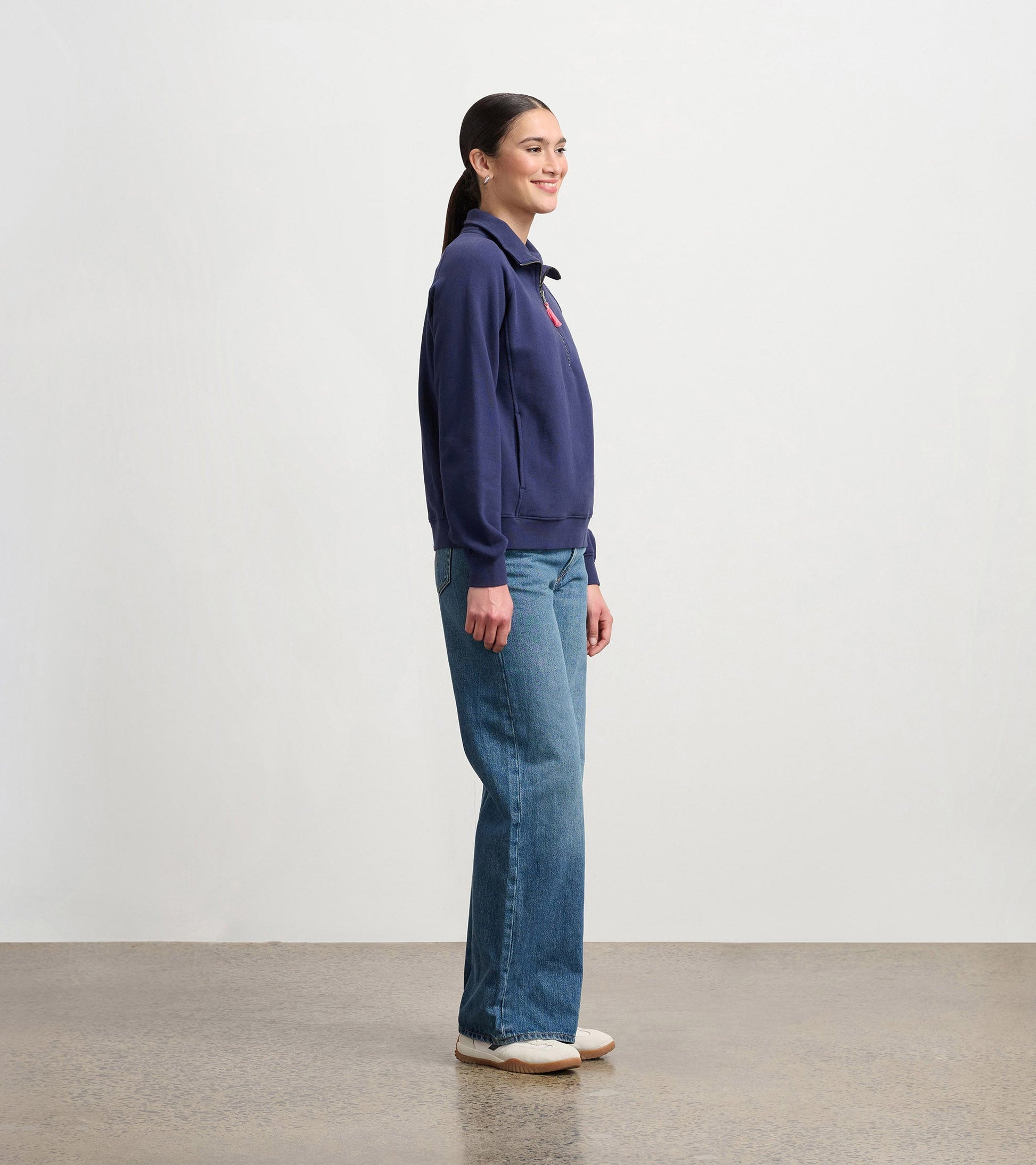 Patriot blue mock neck pullover in a relaxed fit, paired with light blue jeans, shown from the side.
