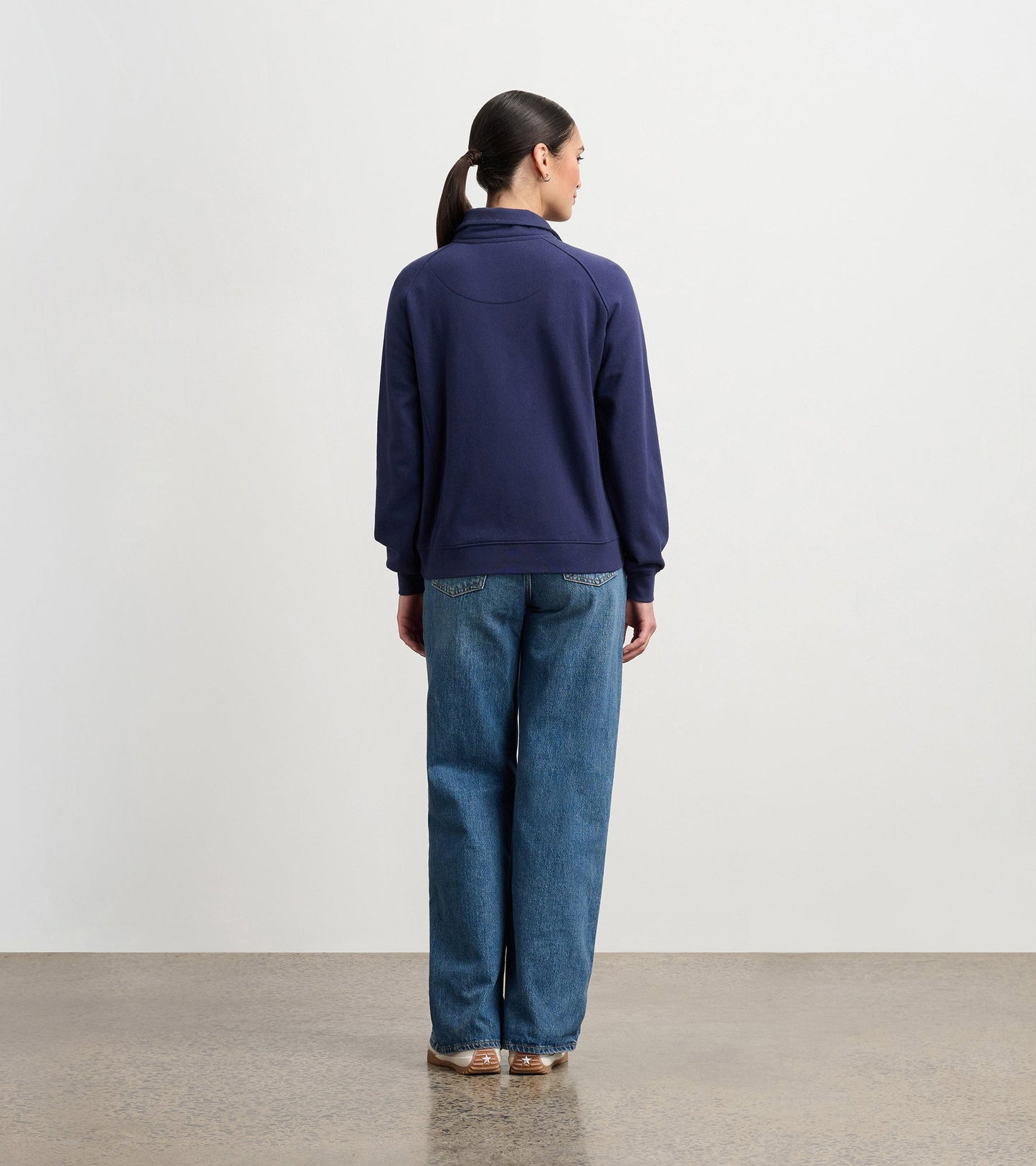 Mock neck pullover in patriot blue, featuring a relaxed fit and long sleeves, worn with wide-leg jeans from a back view.