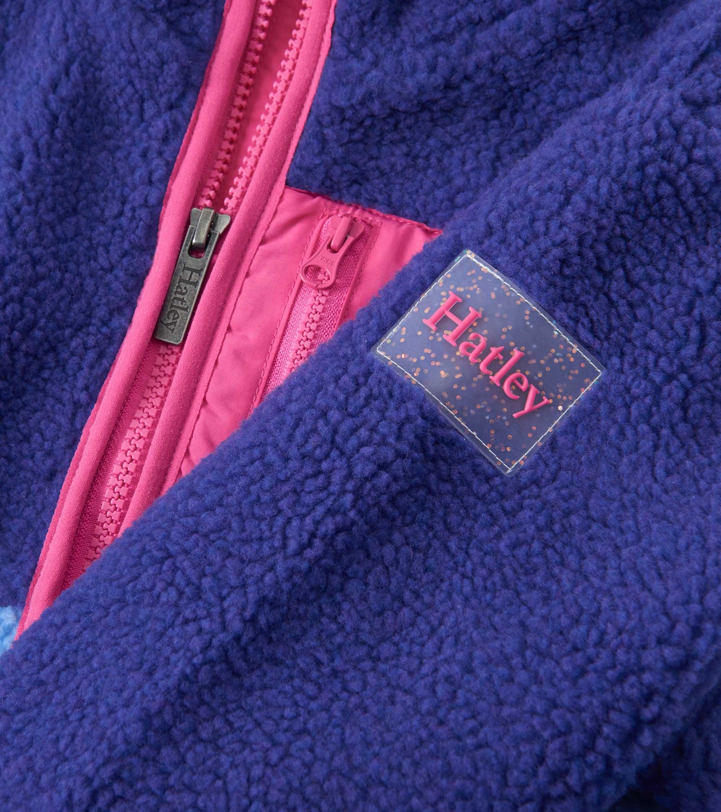 Royal blue faux sherpa jacket with pink accents and zipper, featuring a soft texture and cozy design.