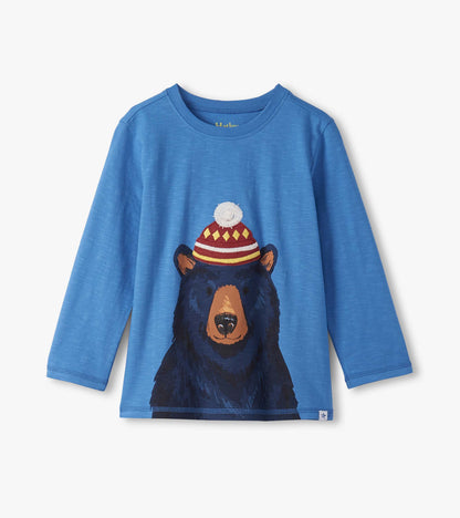 Blue long sleeve tee featuring a graphic of a bear wearing a colorful hat, suitable for boys.