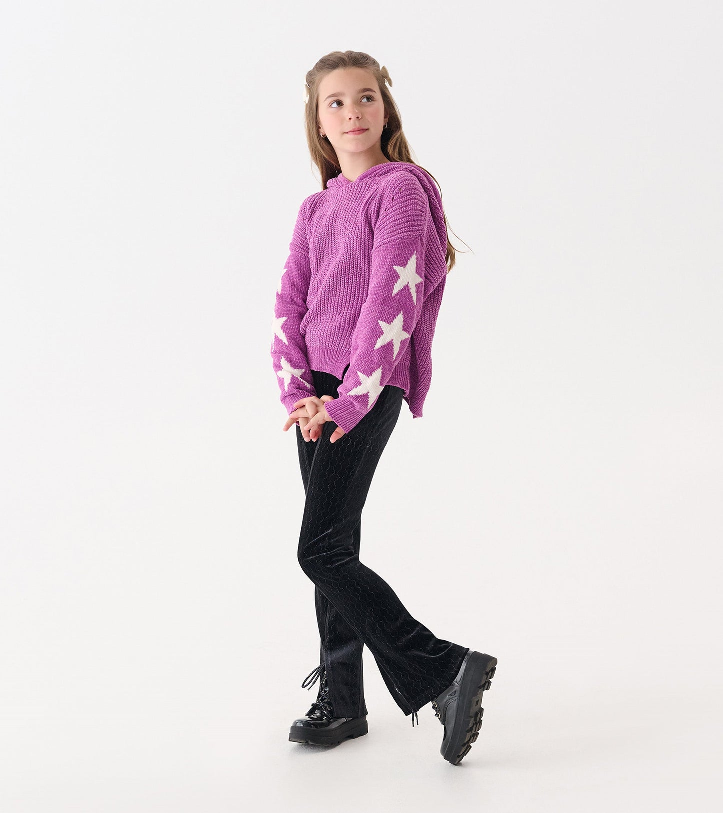 Purple chenille pullover sweater with white star patterns, paired with black textured pants and black shoes.