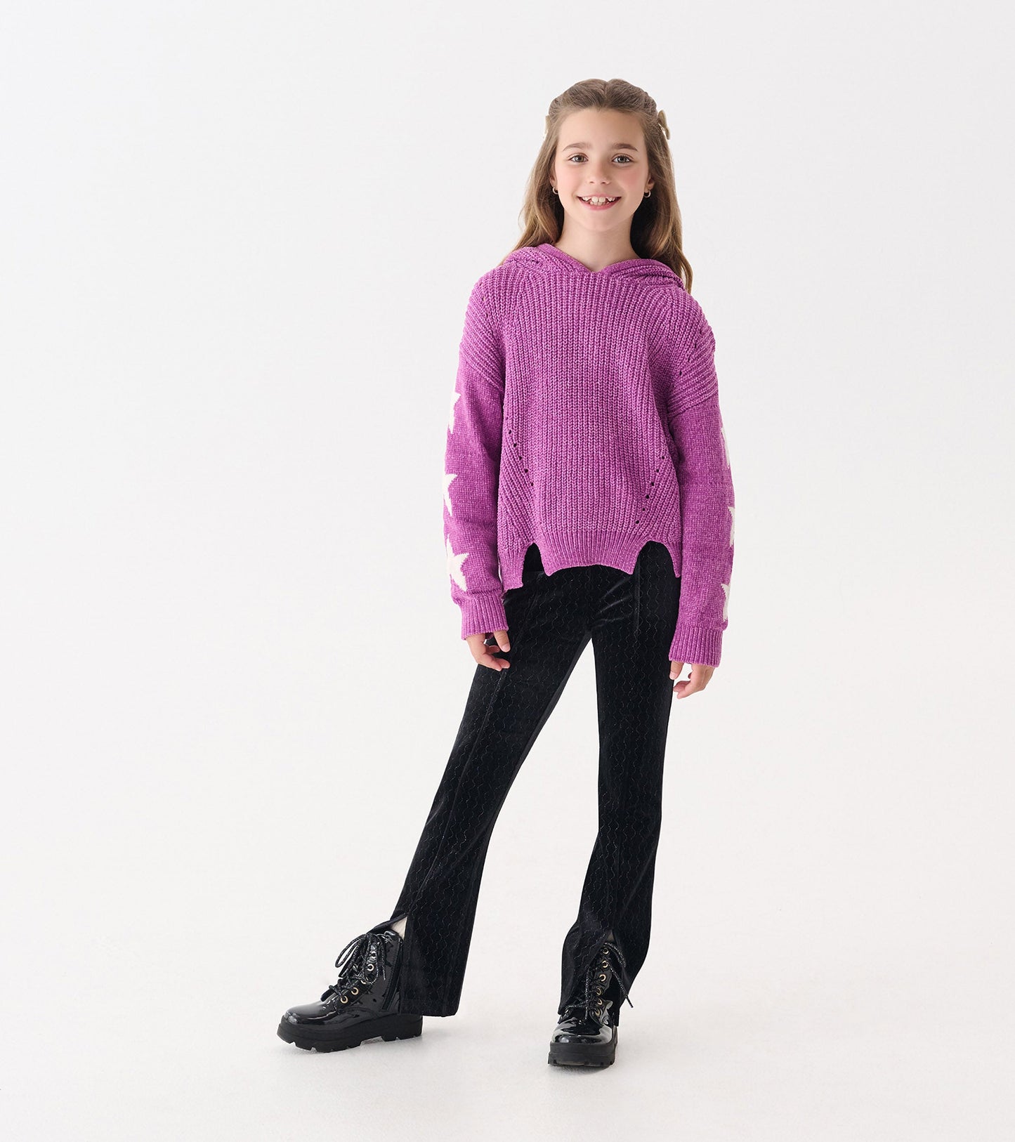Radiant orchid chenille pullover sweater with star patterns, hood, and a relaxed fit, paired with black flared pants.