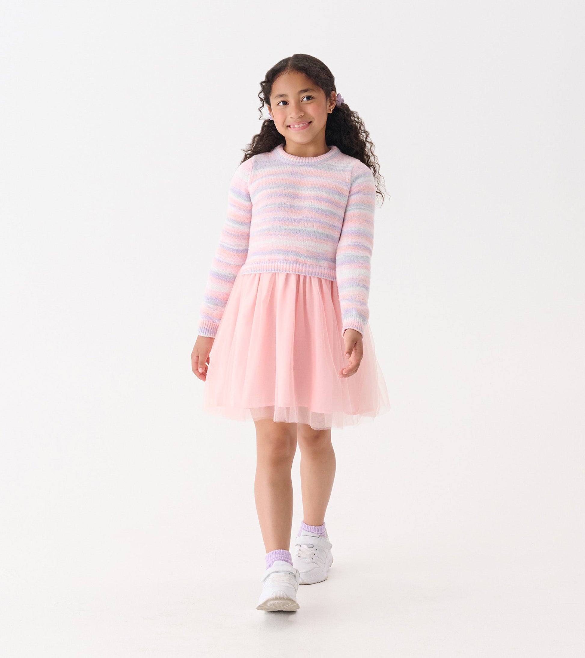 Pastel striped fuzzy sweater with a pink tulle skirt, worn by a girl walking, showcasing a playful and stylish look.