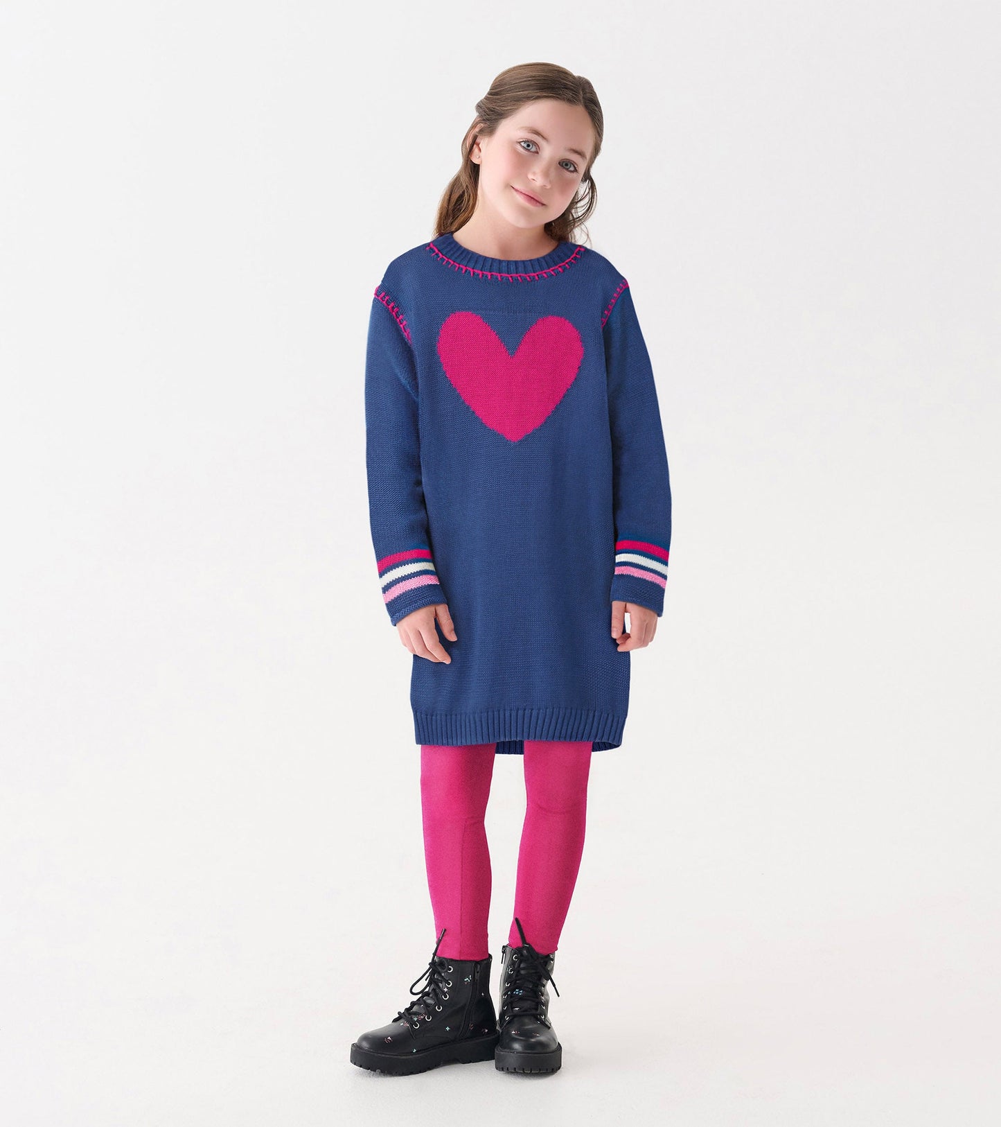 Navy sweater dress with a pink heart design, long sleeves, and striped cuffs, paired with pink leggings and black boots.