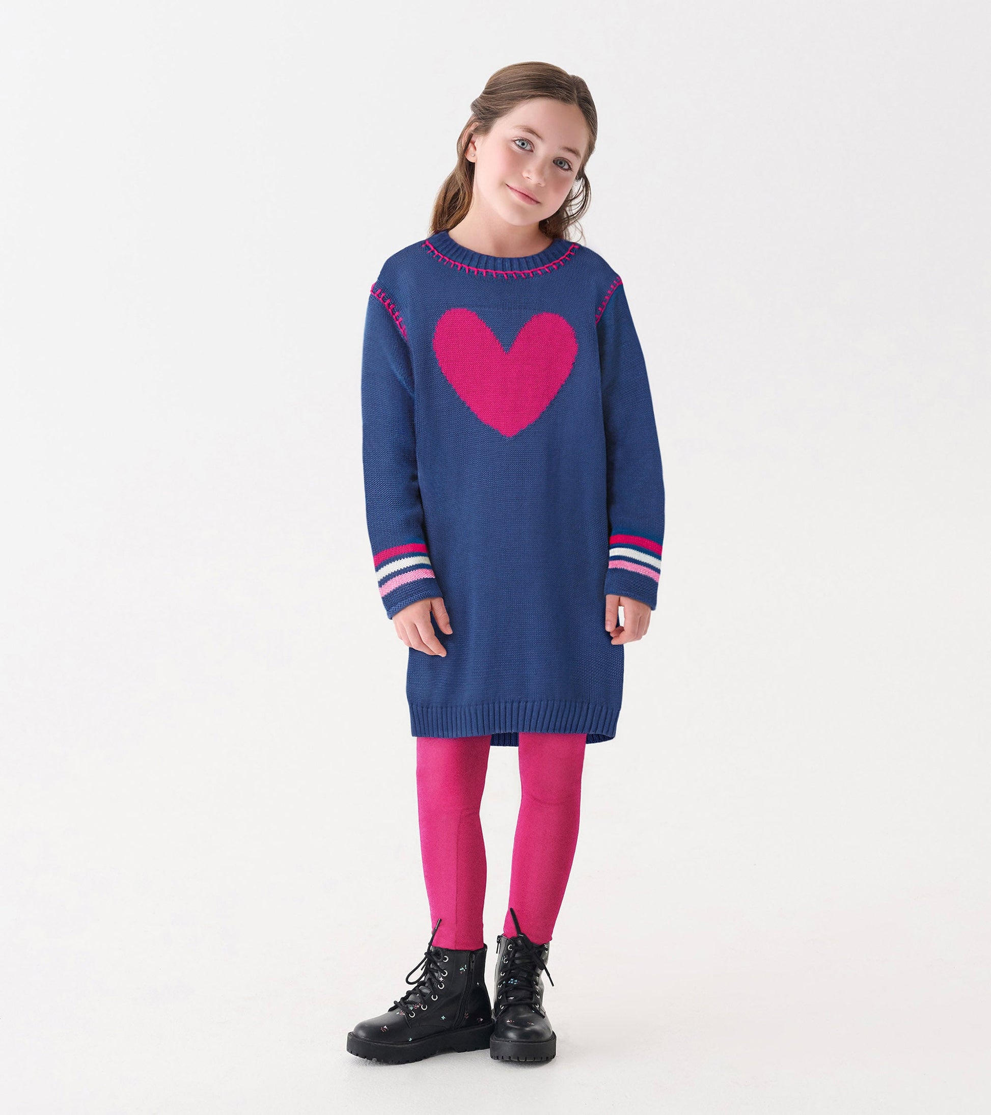 Navy sweater dress with a pink heart design, long sleeves, and striped cuffs, paired with pink leggings and black boots.