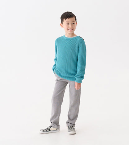 Teal button neck sweater with a textured knit, paired with gray pants and black and white checkered shoes.