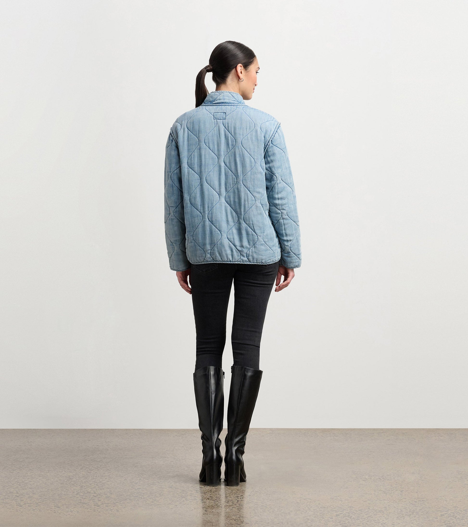 Quilted jacket in washed blue Tencel, featuring a collar and long sleeves, viewed from the back.