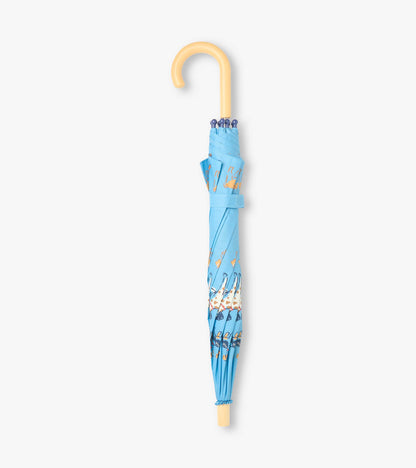 Closed blue kids umbrella with dog print, strap wrap, and curved light wood handle