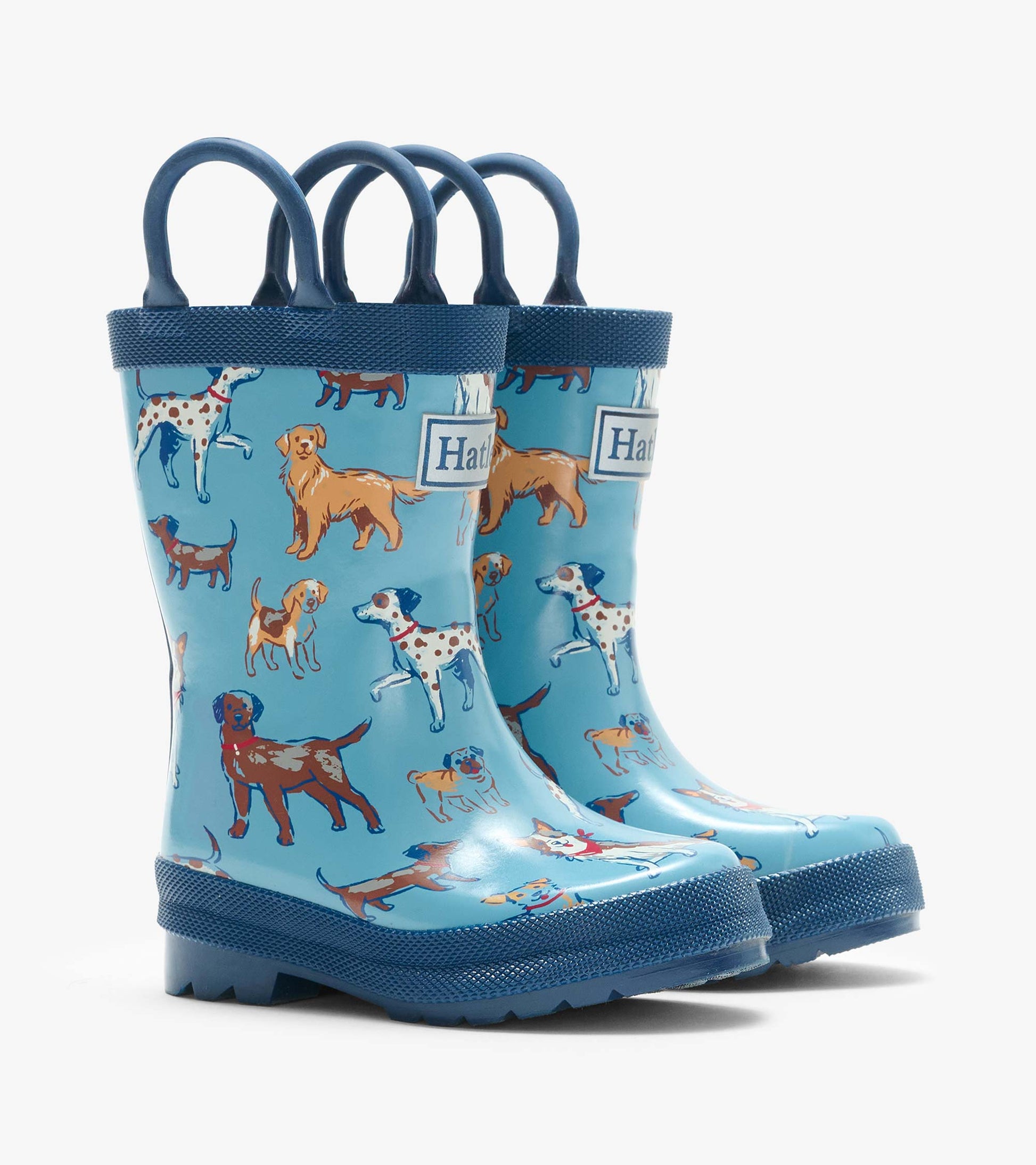 Pair of blue kids rain boots with navy handles and colorful dog print, front angled view