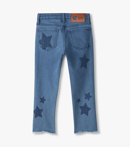 Back view of blue slouchy jeans with dark star print, back pockets, Hatley patch, and frayed hems