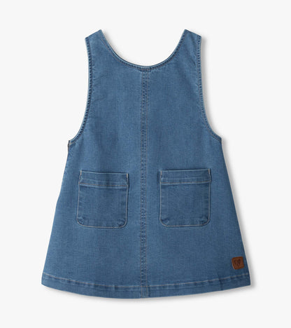 Front of blue pinafore dress with scoop neck, center seam, two front patch pockets, and small logo patch