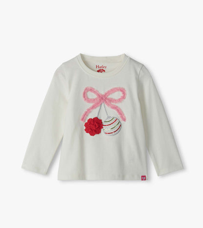 Front view of cream long-sleeve toddler T-shirt with pink bow and ornament graphic on chest
