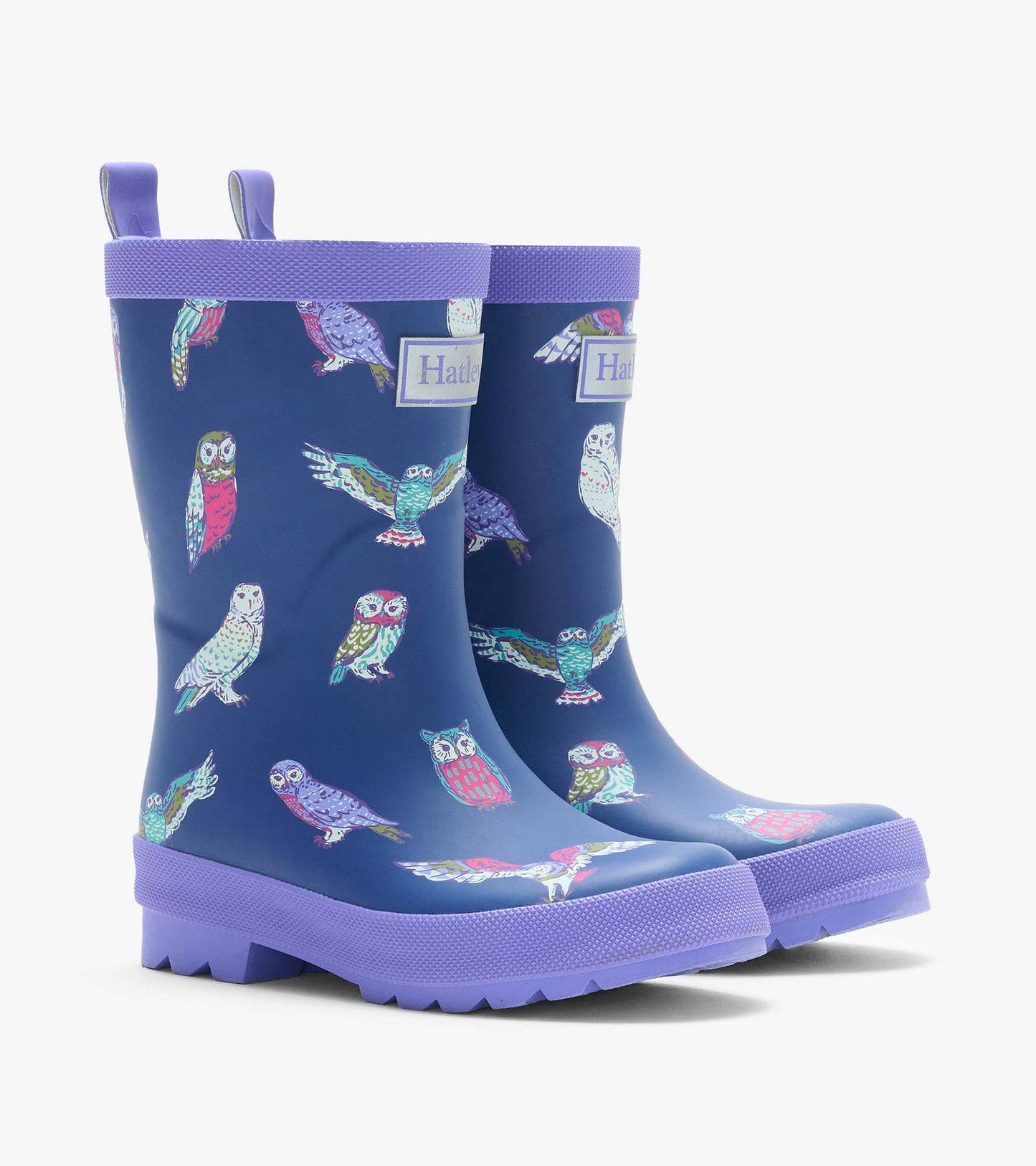 Pair of navy kids rain boots with colorful owl print, purple trim, pull tabs, and lug soles