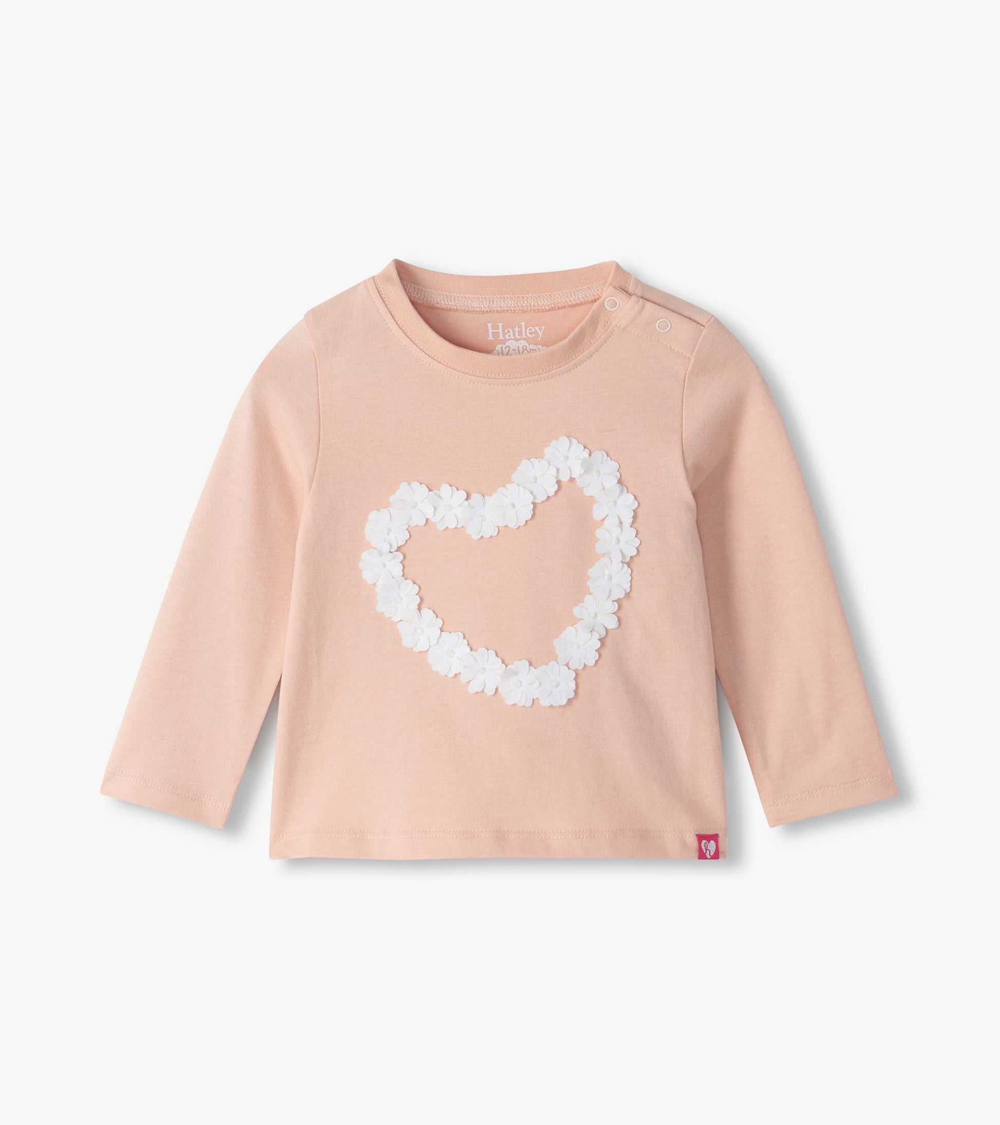 Infant pink long sleeve tee with shoulder snaps and a white floral heart on the front